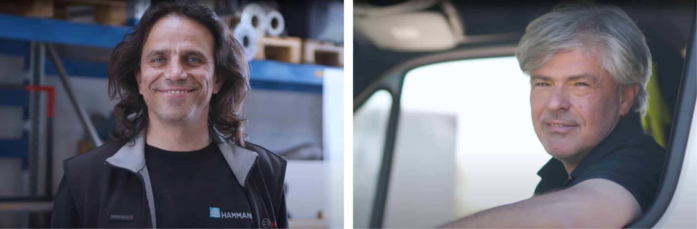 Zwei lächelnde Männer, einer mit langen Haaren und einer schwarzen Jacke, der andere mit kurzen grauen Haaren, sitzen in einem Gemeinschaftsfahrzeug.