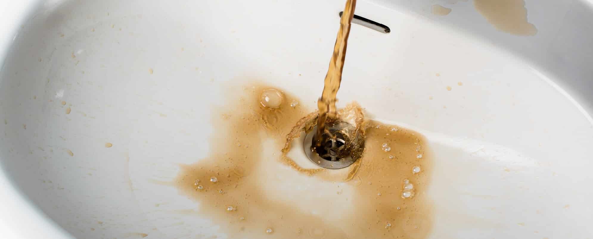 Wenn braunes Wasser aus einem Wasserhahn in ein Waschbecken läuft und schmutzige Flecken um den Abfluss herum hinterlässt, ist eine sofortige Rohrreinigung erforderlich, um weiteren Schaden zu verhindern.
