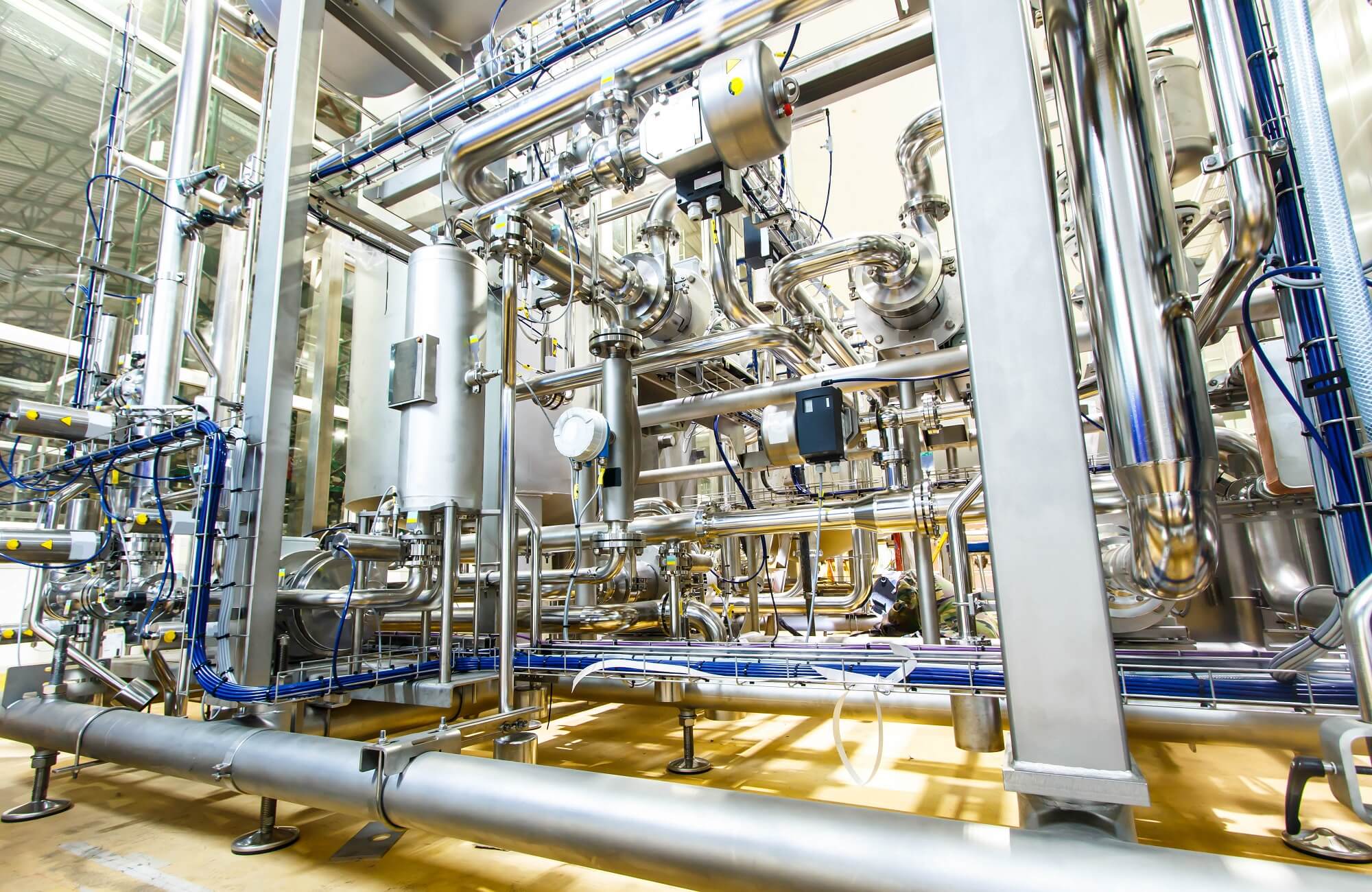 Eine komplexe Industrieanlage mit miteinander verbundenen Metallrohren, Messgeräten und Maschinen in einer hell erleuchteten Kommunalanlage.