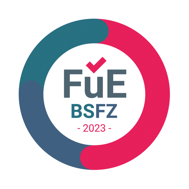 Ein kreisförmiges Logo mit dem Text „FuE BSFZ 2023“ und einem Häkchen in der Mitte. Der äußere Kreis, der Industriestandards symbolisiert, ist blau und rosa.